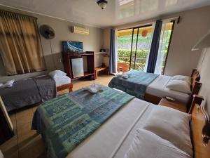 a hotel room with two beds and a television at Hotel Iris Arenal in Fortuna +48 photos