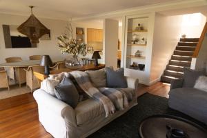 a living room with a couch and a table at Villa 3br Tempranillo Villa located within Cypress Lakes Resort in Pokolbin