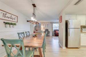 a kitchen and dining room with a table and a refrigerator at 10 Mi to Anna Maria Island Bradenton Family Home in Bradenton