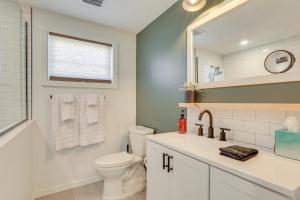 a bathroom with a toilet and a sink and a mirror at 10 Mi to Anna Maria Island Bradenton Family Home in Bradenton +22 photos