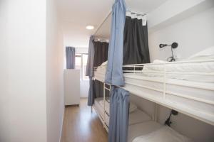 Cette chambre comprend 2 lits superposés dotés de rideaux bleus. dans l'établissement Porto Automatic, à Porto 43 autres photos