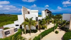 Luftblick auf ein weißes Gebäude mit Palmen in der Unterkunft Corcomoran Luxury beachfront house in Telchac Puerto