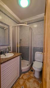 a bathroom with a toilet and a sink and a shower at Vila Rafaella - Praia de São Rafael in Sesmarias