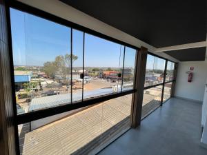 a room with a large window with a view of a parking lot at Suíte Gold com varanda e Hidro 302 in Santo Antônio do Descoberto