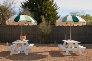two picnic tables with umbrellas on top of them at The Keith Motel in Tootgarook