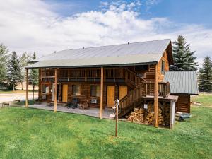 a log cabin with a metal roof and a deck at Teton Peaks Resort in Tetonia