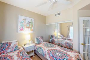 ein Schlafzimmer mit zwei Betten und einem Spiegel in der Unterkunft Vistoso Resort Casita #132 in Tortolita + 25 Fotos