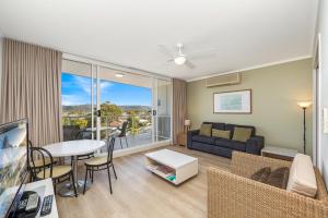 a living room with a couch and a table at Hinterland Luxury - 1 Bedroom Hinterland View Apt in Ettalong Beach