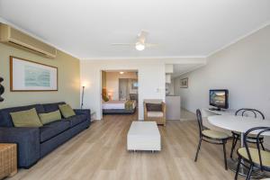 a living room with a couch and a table at Hinterland Luxury - 1 Bedroom Hinterland View Apt in Ettalong Beach