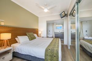 a bedroom with a large white bed and a bathroom at Hinterland Luxury - 1 Bedroom Hinterland View Apt in Ettalong Beach +14 photos