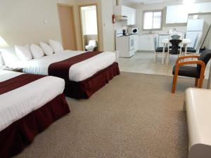 ein Hotelzimmer mit 2 Betten und einer Küche in der Unterkunft Canadas Best Value Inn & Suites-Vernon in Vernon