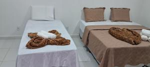 two beds in a room with two beds with blankets at Pousada Jardim da Lagoa-BA in Bom Jesus da Lapa