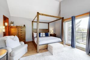 a bedroom with a canopy bed and a white couch at Lakeview Townhome Unit A5 in Avon
