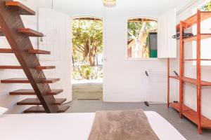a room with white walls and a wooden staircase at Pousada da Praça Caraíva in Caraíva