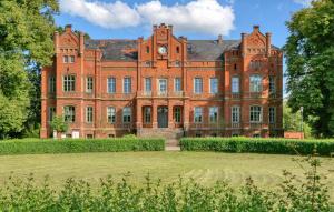 a large red brick building with a clock on it at Gorgeous Apartment In Krakow Am See in Krakow am See