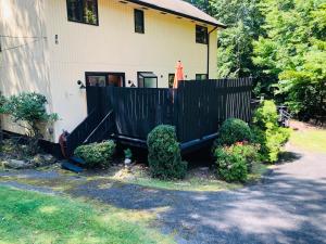 a house with a black fence in front of it at Bethel Escape Hot Tub 4 beds Game Room and Fire pit Fully Stocked Kitchen in Smallwood +49 photos