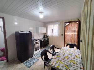 a kitchen with a table and chairs in a room at Kit do Madruga in Ilha do Mel