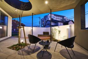 un patio con sedie e tavolo in una casa di 水響邸-blue sound villa- a Karatsu