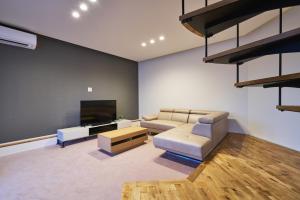 un soggiorno con divano e TV a schermo piatto di 水響邸-blue sound villa- a Karatsu