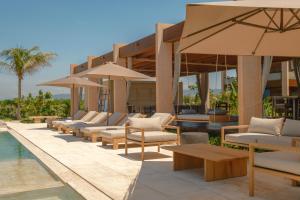 a resort with a pool and chairs and umbrellas at ONTO House Puerto Escondido in Tlachicón