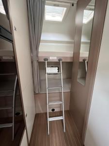 una scala in una piccola stanza con un lucernario di Autocaravanmadrid a El Espinar