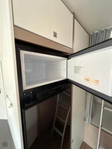 una cucina con armadietti bianchi e lavastoviglie di Autocaravanmadrid a El Espinar