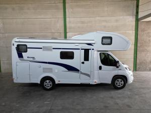 un camper bianco parcheggiato in un parcheggio di Autocaravanmadrid a El Espinar