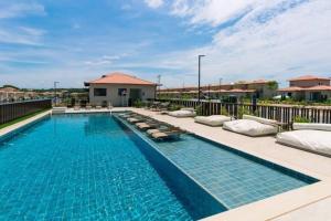 a swimming pool with chaise lounges on a balcony at Casa Vida Aretê in Búzios