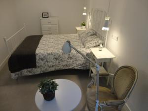 a bedroom with a bed and a table and a chair at Casa Aveiro Canal da Ria in Aveiro