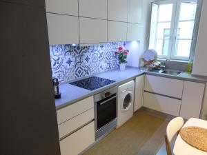 a kitchen with white cabinets and a washer and dryer at Casa Aveiro Canal da Ria in Aveiro +13 photos