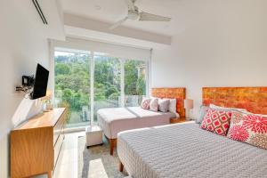 a bedroom with two beds and a tv and a window at Puerto Vallarta Resort Condo, On-Site Beach Access in Puerto Vallarta +37 photos