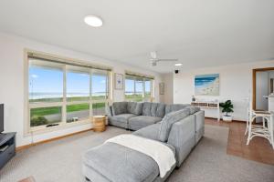 米德尔顿Esplanade Escape Absolute Beachfront WIFI-NBN的客厅设有灰色的沙发和大窗户