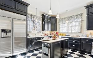 cocina con armarios negros y suelo a cuadros en The Wynne House Inn, en Holly Springs