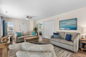un soggiorno con due divani e una TV di Beach House with Pool - North Myrtle Beach a Myrtle Beach Altre 40 foto