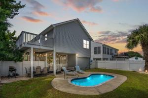 a house with a swimming pool in the yard at Beach House with Pool - North Myrtle Beach in Myrtle Beach