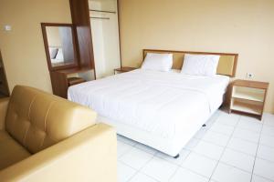 a bedroom with a large white bed and a couch at Nusantara Rooms Mutiara By Reccoma in Bekasi +33 photos