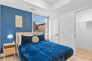 ナイアガラ・フォールズにあるVibrant 2BR Gateway with Free Parking & 7 Mins to the Fallsの青い壁のベッドルーム1室(ベッド1台付)