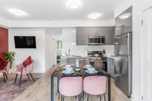 ナイアガラ・フォールズにあるVibrant 2BR Gateway with Free Parking & 7 Mins to the Fallsのキッチン(テーブル、ピンクの椅子付)