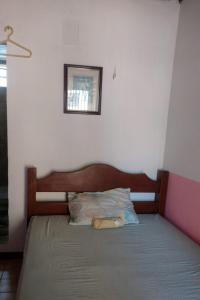 a bed with a wooden headboard in a bedroom at Hostel Residence Girassol in Belém