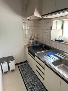 a small kitchen with a sink and a stove at 南箱根 熱海 貸切別荘 リゾートハウス カームスペース ResortHouse CalmSpace in Kannami
