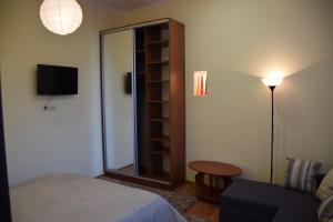 ein Schlafzimmer mit einem Bett, einem Spiegel und einer Lampe in der Unterkunft Near Citadel Apartment 2 in Lwiw