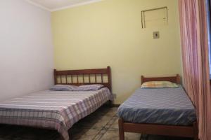 een kamer met 2 bedden in een kamer bij Casa da Fran in Maresias