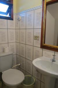 a bathroom with a toilet and a sink and a mirror at Casa da Fran in Maresias