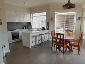 a kitchen and dining room with a table and chairs at Sophisticated Elegance at the Gardens in Albury