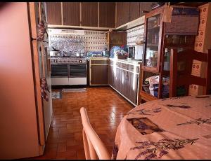a kitchen with a stove and a table in it at Mataireva Lodge TOUR in Arue
