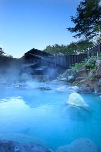 a blue river with a rock in the water at Zao Kokusai Hotel in Zaō Onsen