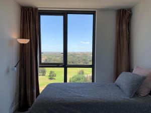 a bedroom with a bed and a large window at Panoramic views in luxurious brand new apartment in Sydney +26 photos