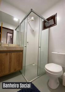 a bathroom with a toilet and a glass shower at Chalé Exclusivo Condomínio Águas da Serra in Bananeiras