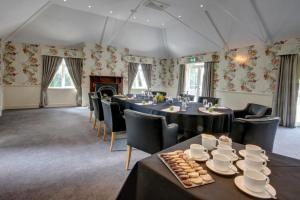 a banquet room with tables and chairs and a fireplace at The Coed-Y-Mwstwr Hotel in Bridgend