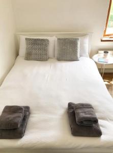 a large white bed with two towels on it at Hawtհorn Guestհouse in Cambridge
